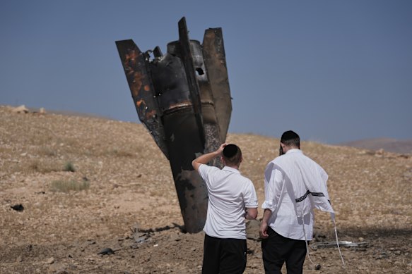 People inspect the wreckage of an Iranian missile that landed near the West Bank city of Jericho on Monday.