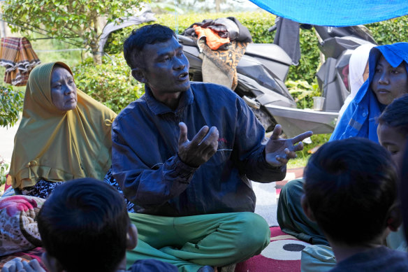 Enjot talks to family members at their temporary shelter in Cianjur, West Java, Indonesia.