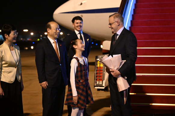 A local schoolgirl presents a gift of flowers to the prime minister.