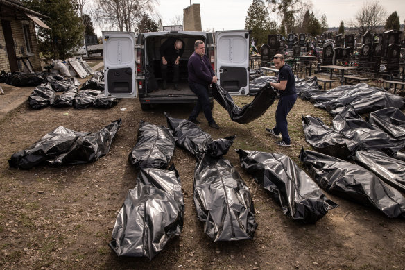 Cemetery workers unload bodies of civilians killed in and around Bucha before they are transported to the morgue on April 7.