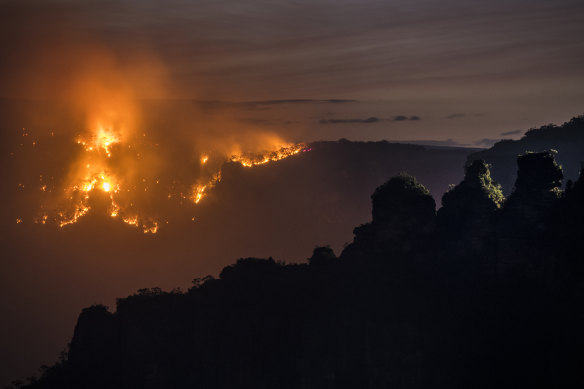 The Ruined Castle fire burns under strong westerly winds in front of Mount Solitary at Echo Point in Katoomba.