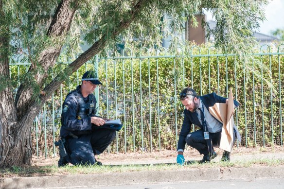 Police officers comb the streets around Crawford High School for evidence on Saturday morning after a fatal stabbing on Friday.