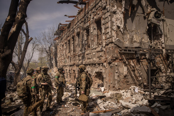 Members of the Ukrainian military walk amid debris after a shopping centre and surrounding buildings were hit by a Russian missile strike in Kharkiv on Saturday.