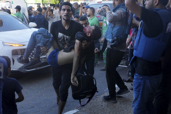 Palestinians wounded in the Israeli bombardment of the Gaza Strip are brought to a treatment room of Al Aqsa Hospital on Saturday (AEDT).