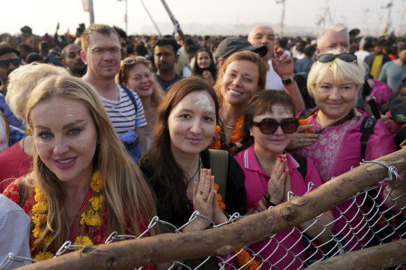 Devotees from foreign countries gather to watch Indian Naga Sadhus, or naked Hindu holy men, participate in a procession towards the water.