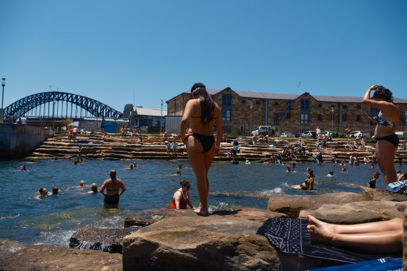 Swimmers and sunbakers make the most of warming weather at Marrinawi Cove, at the north-east corner of Barangaroo Reserve.