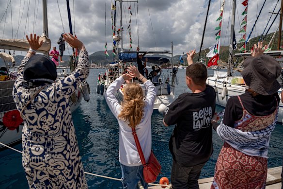 Pessoas acenam para barcos pertencentes à Flotilha Global Sumud no porto de Marmaris, Turquia, na quinta-feira.