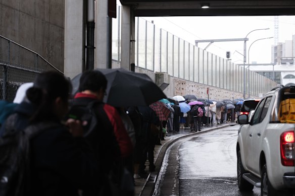 Commuters at Lidcombe Station waited more than an hour in the rain to board replacement buses.