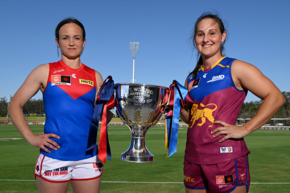 Daisy Pearce of the Demons and Breanna Koenen of the Lions pose with the trophy.