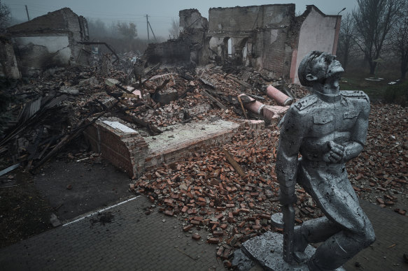 A statue of a Soviet soldier against the background of a house of culture destroyed by rocket fire on the outskirts of the city in Avdiivka, Ukraine. 
