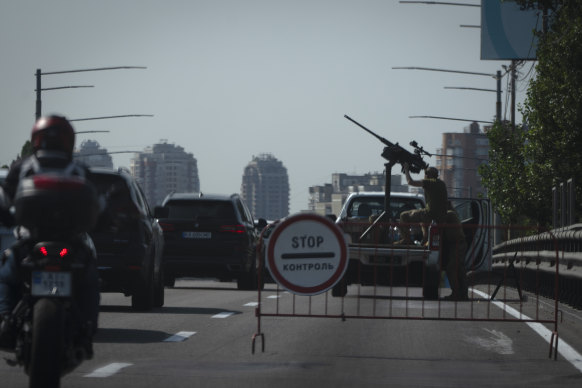 Ukrainian soldiers guard the sky with a machine-gun on a road in Kyiv during a Russian missile and drone attack.