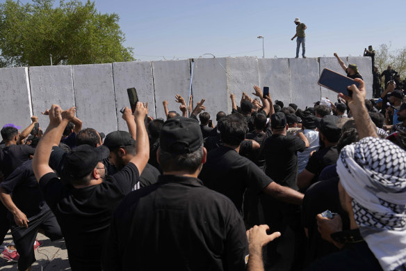 Supporters of influential Shiite cleric Muqtada al-Sadr try to remove concrete barriers in the Green Zone area in Baghdad in August.