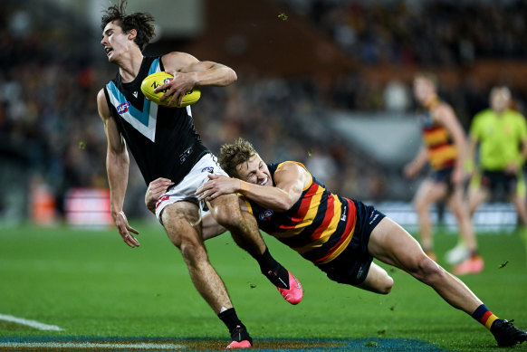 Connor Rozee is tackled by Jordan Dawson of the Crows.