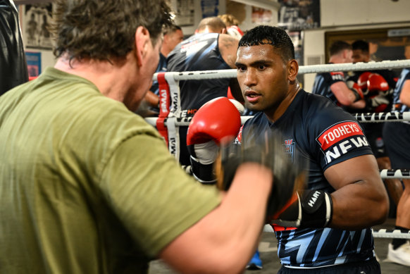 Tevita Pangai jnr spars with Mark Carroll in Origin camp on Tuesday.