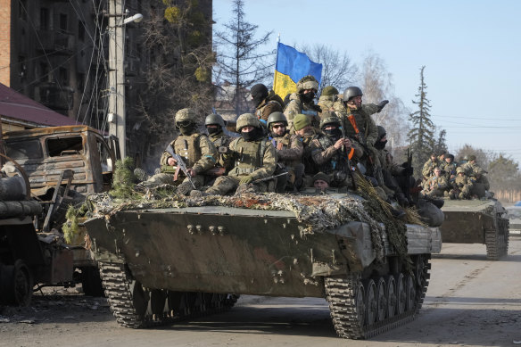 Ukrainian soldiers ride on APC through the town of Trostsyanets.