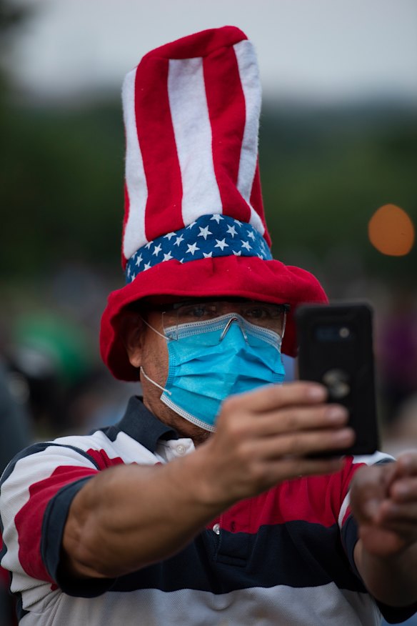 A person takes a photo while waiting for fireworks on the National Mall in Washington, on July 4, 2020. 