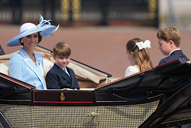 Kate Princess of Wales, left with her children Prince Louis, Princess Charlotte and Prince George ride in an open top carriage during Trooping The Colour