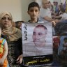Amro el Halabi holds a picture of his father, Mohammed, who was the Gaza director of the international charity World Vision, now found guilty of diverting sums to Hamas that exceed its total budget,