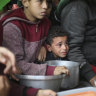 Palestinians line up for free food distribution during the ongoing Israeli air and ground offensive in Khan Younis, Gaza Strip, last month.