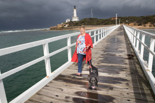 Perks of the job: House-sitter Petrina Dakin takes puppy Winnie for a walk at the Point Lonsdale pier.