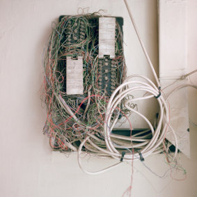 A tangle of phone wires and cables extends from a junction box in the basement. 