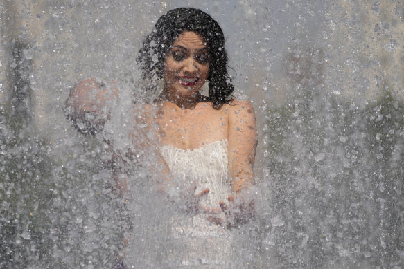 A member of an Australian cabaret and circus troupe cools down in a fountain on the Southbank in London as a heatwave sweeps across Britain.