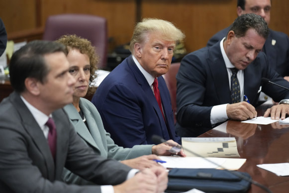 Former president Donald Trump sits at the defence table with his legal team.