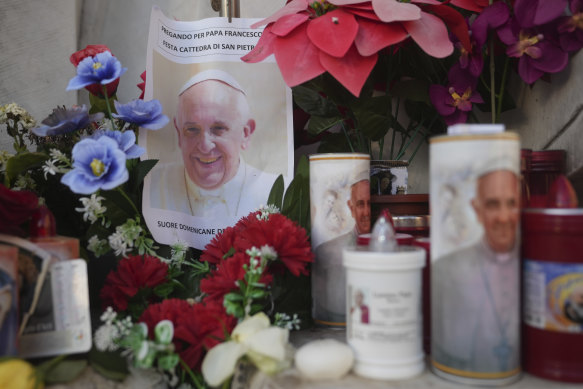 Candles and a photo of Pope Francis are seen in front of the Agostino Gemelli Polyclinic in Rome on Saturday, where the pontiff is being treated.