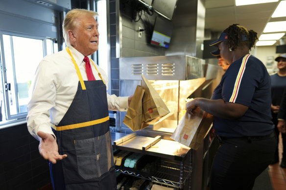 Donald Trump holds an order near the drive-thru window during a visit to McDonald’s.