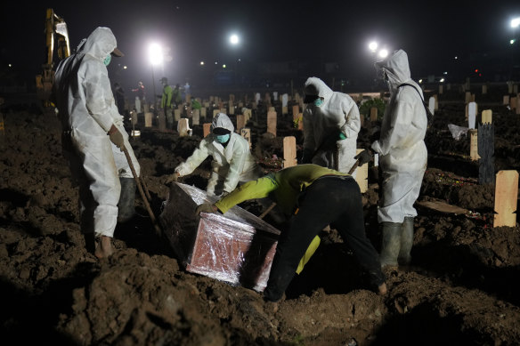 Workers bury a COVID-19 victim at Rorotan Cemetery in Jakarta, Indonesia.