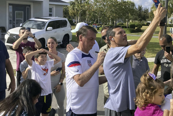 Former Brazilian president Jair Bolsonaro, centre, meets supporters outside a holiday home where he is staying near Orlando, Florida, on Wednesday.