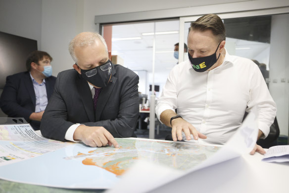 Prime Minister Scott Morrison and Brisbane lord mayor Adrian Schrinner consult a map during a media conference about the flood situation on February 28.