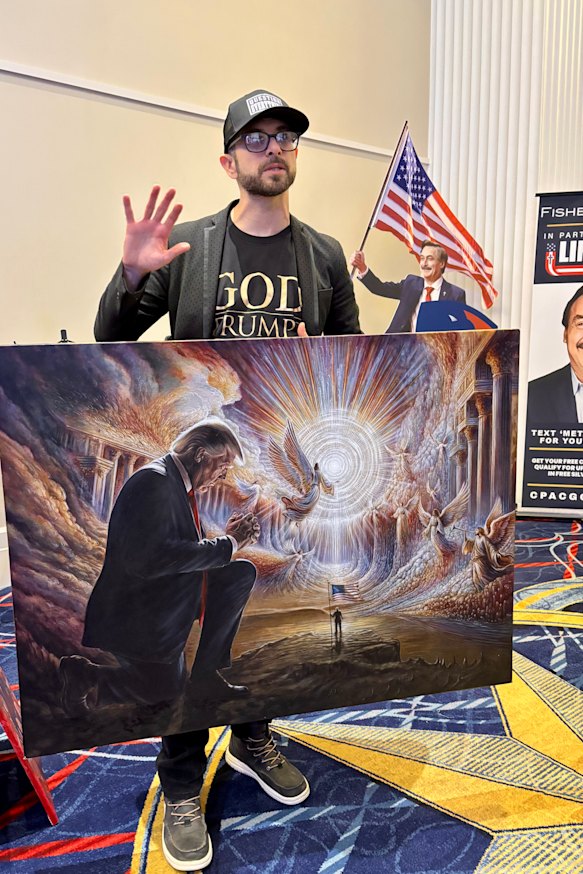 Artist Seth Leibowitz at the conference with his painting of Trump.