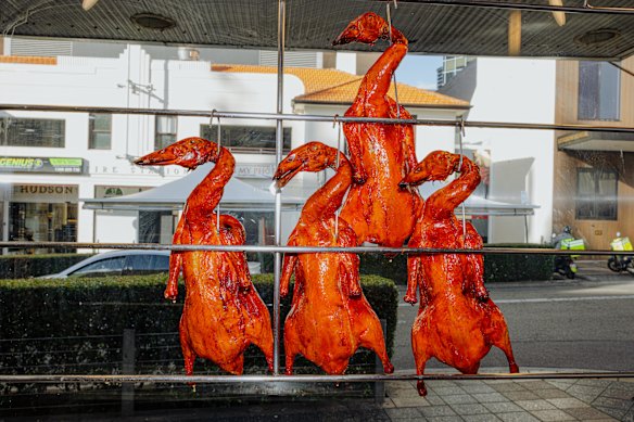 Lacquered ducks hang in the window.