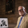 Ross Gittins in the Great Hall of Sydney University, with a portrait of himself taken in 1982.
