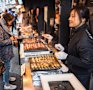 Street food being prepared at one of the many seafood stalls in the outer market of Tsukiji Fish Market. 