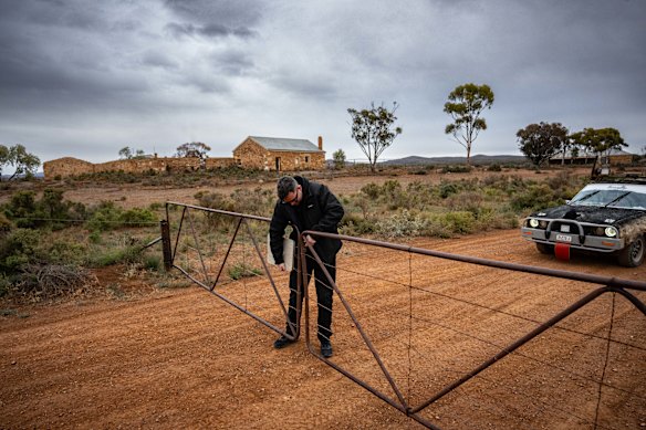  A trek participant opens a gate on an outback road between Burra and Arkaroola. 