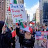 People hold signs in New York thanking President Donald Trump. 