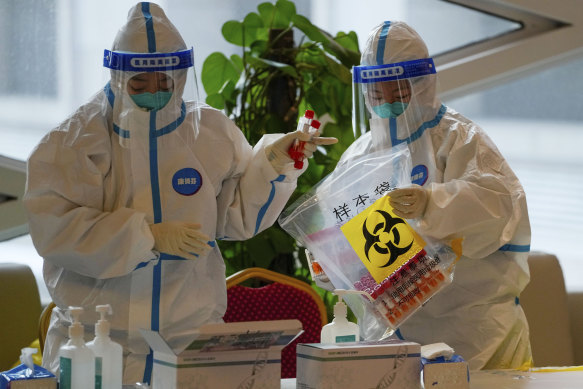 Health workers wearing protective suits store COVID-19 test samples at a hotel used for COVID quarantine on March 20 in the Yanqing district of Beijing. 