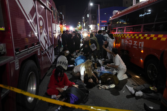 Yaralılara Ekim 2022'de Seul'de yaşanan kaza mahalline yakın bir sokakta yardım ediliyor. 