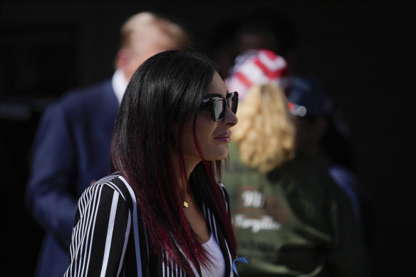 Trump (in background) appears to augment the conspiracy theories Loomer airs.