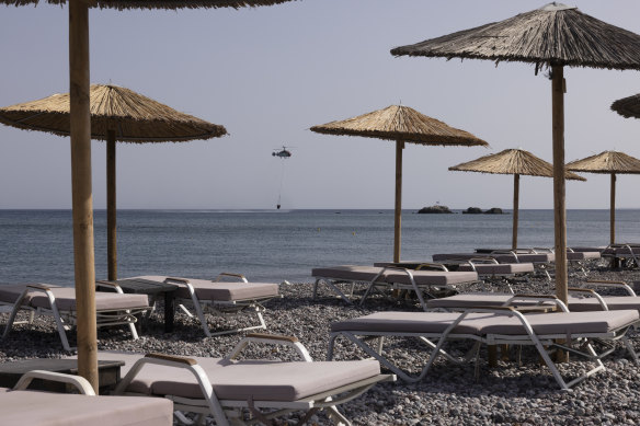 A firefighting helicopter seen from an empty resort in Gennadi, Greece, following summer wildfires.