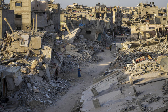 Palestinians walk through the destruction left by the Israeli air and ground offensive on Khan Younis, Gaza Strip.
