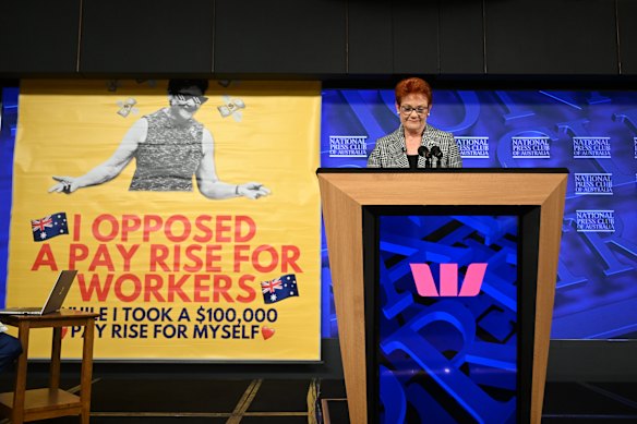 Pauline Hanson and the banner that earlier disrupted her first address to the National Press Club.