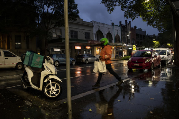 A food delivery rider braves the wintry conditions in Surry Hills on Friday night.