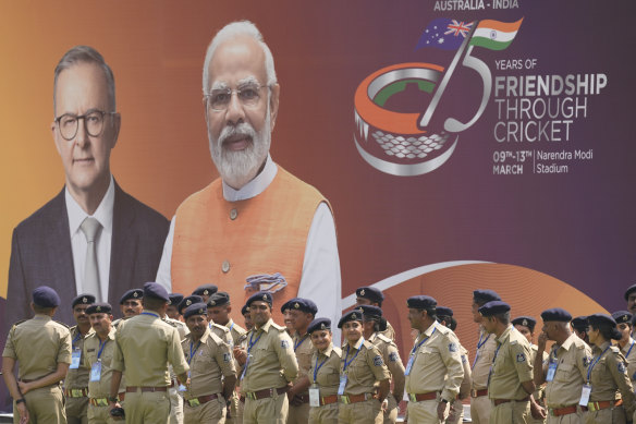 Indian police in front of a board featuring Prime Minister Anthony Albanese and Indian Prime Minister Narendra Modi in Ahmedabad.