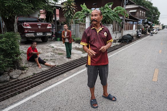 Neighbours gather outside the Donhomla  family home in Kalasin. 