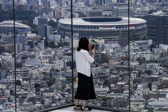 A person takes a picture from an observation deck of the National Stadium, where the Opening Ceremony will be held on July 23. 