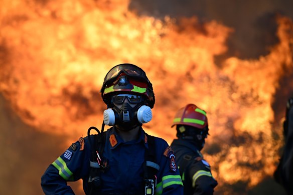 A firefighter stands as flames rising during a wildfire near Porto Germeno, northwest of Athens, on Sunday.