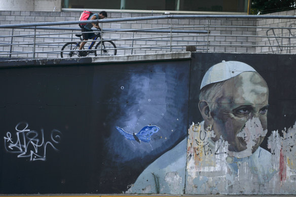 Bir bisikletçi, 2 Mart'ta Arjantin'in Buenos Aires kentinde, Papa Francis'in yıpranmış bir duvar resminin yakınındaki bir rampada bisikletiyle pedal çeviriyor. 
